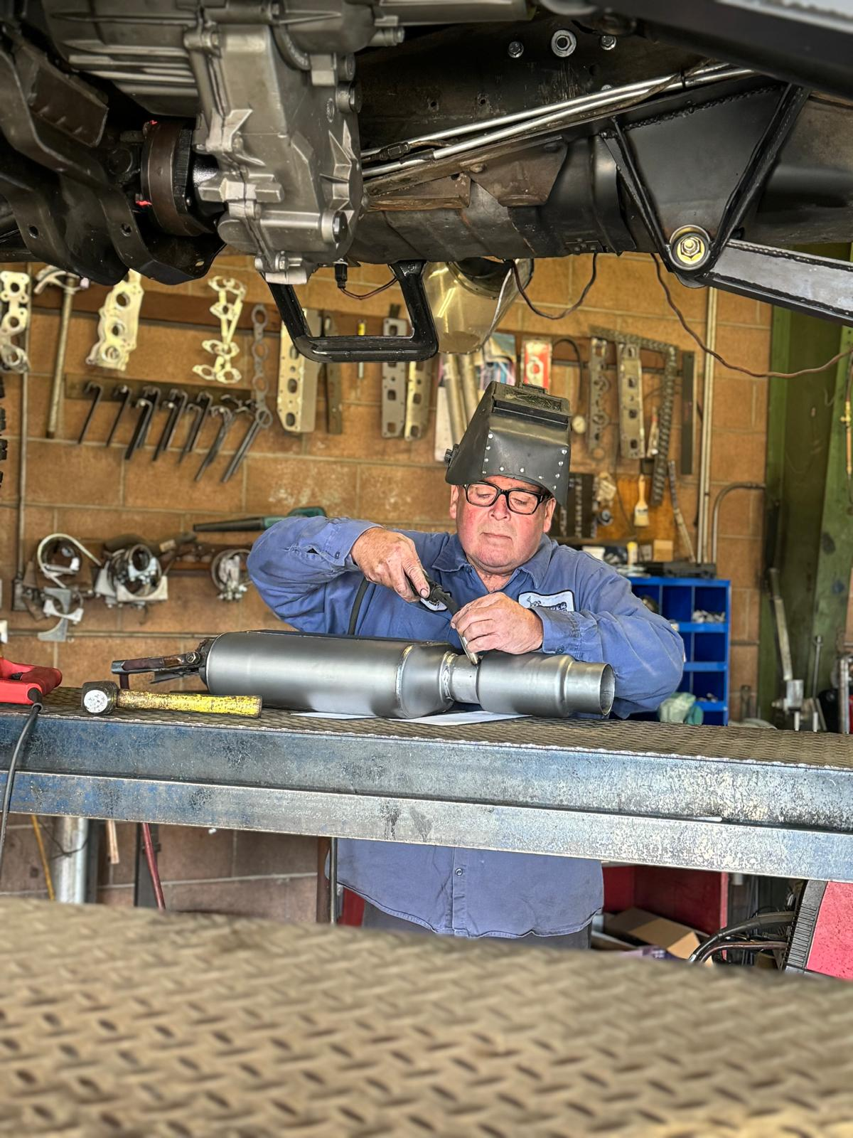 Technician fitting exhaust muffler components